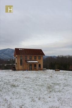 a small wooden house sitting in the middle of a snow covered field