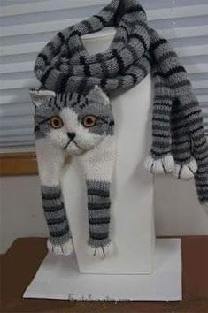 a knitted cat scarf on top of a white mannequin