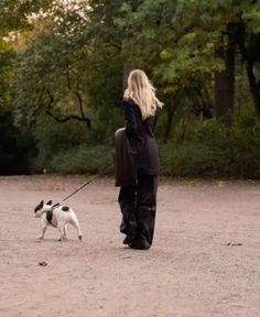 a woman walking her dog in the park