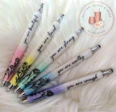 six pens with writing on them sitting in a pile