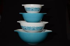 four blue and white bowls stacked on top of each other in the shape of flowers