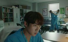 two men in scrubs are working on an office