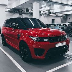 a red range rover parked in a parking garage