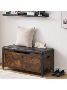 a wooden bench with a cushion and some shoes on the floor in front of it