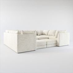 a white sectional couch sitting on top of a white floor