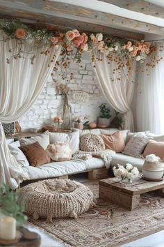 a living room filled with lots of furniture and flowers hanging from the ceiling above it