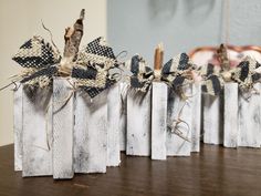 four wooden blocks with black and white bows on them sitting on top of a table