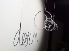 the word design is written on a wall next to some metal rings hanging from it's sides