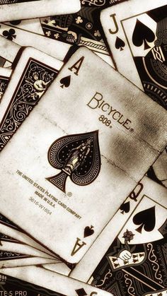 a pile of playing cards sitting on top of each other in front of a black and white background