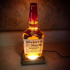 a bottle that is sitting on top of a wooden stand with a light in it