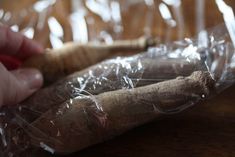 a person holding a wooden stick in plastic wrap