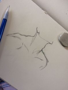 a pencil drawing of a woman's torso on paper next to a blue marker