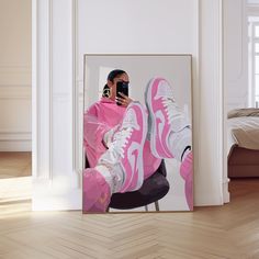 a woman taking a selfie with her cell phone in front of a pink sneaker