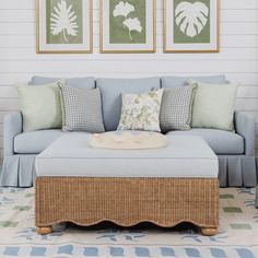 a living room with blue couches and pictures on the wall above them, along with a coffee table