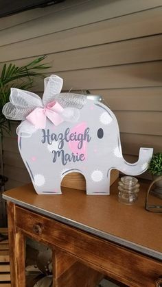 an elephant shaped light up sign with a pink bow