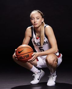 a female basketball player holding a ball in front of a black background with the word efl written on it