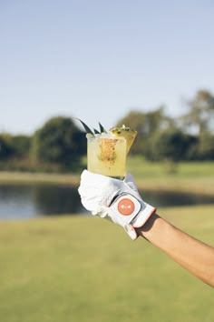 a person holding up a drink in their hand