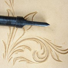 a pen sitting on top of a piece of paper next to a drawing with swirls