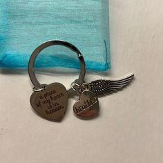 a heart shaped keychain with an angel wing on it