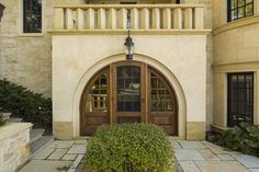 an entrance to a large building with two wooden doors