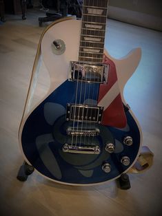 a blue and white guitar sitting on top of a wooden floor