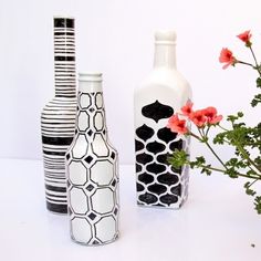 three vases with flowers in them sitting next to each other on a white surface