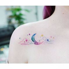 a woman with a tattoo on her shoulder that has the moon and stars painted on it