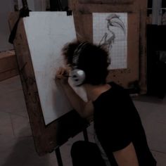 a person sitting in front of a drawing board