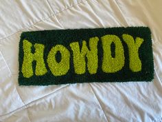 a green door mat with the word rowdy written in yellow letters on top of it