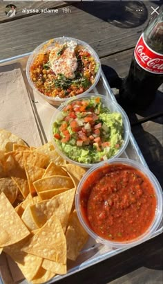 a tray filled with chips, salsa and guacamole