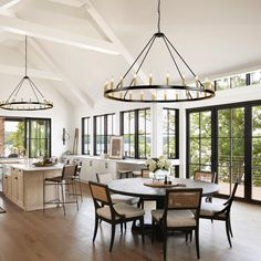 a large open kitchen and dining room area with wood flooring, white walls and ceiling