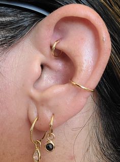 a close up of a person's ear with two different types of earrings on it