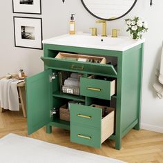 a bathroom vanity with green drawers and white counter top, gold faucet above the sink