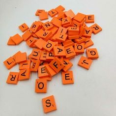 orange letters spelling out the word's in english and spanish are scattered on a white surface