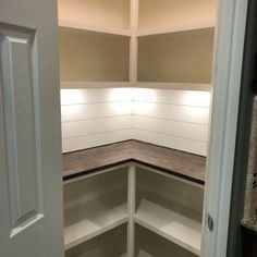 an empty pantry with white walls and wood flooring