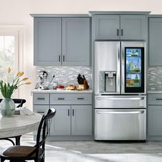 a kitchen with gray cabinets and stainless steel appliances