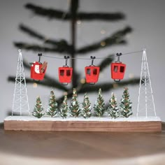 a small christmas tree is in the middle of a table with red chairs on it