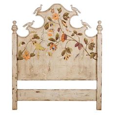 an old white painted headboard with birds and flowers on the top, against a white background