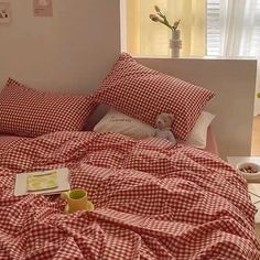 a red and white checkered comforter on a bed