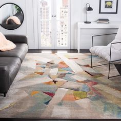 a living room area with a couch, chair and rug in front of a window