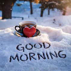 a cup of coffee sitting on top of snow with the words good morning written in it