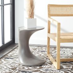 a chair next to a table with a plant in it