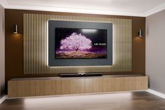 an entertainment center with a large television mounted on it's wall, displaying the image of a tree