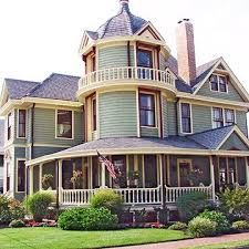 an old victorian style house with large porches and balconies on the second floor