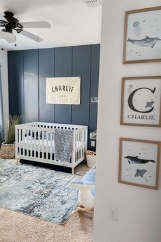 a baby's room with blue walls and pictures on the wall, including a crib