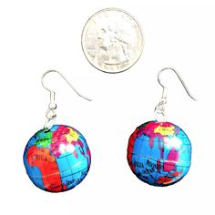 a pair of earrings with the colors of the world painted on it and a penny