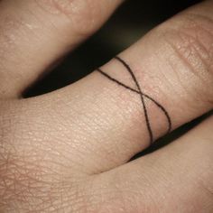 a close up of a person's hand with a small tattoo on the middle finger