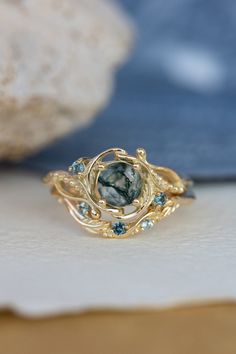 a close up of a ring on a table with some rocks in the back ground