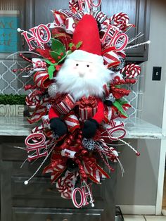 a christmas wreath with santa claus and candy canes hanging on the front door,