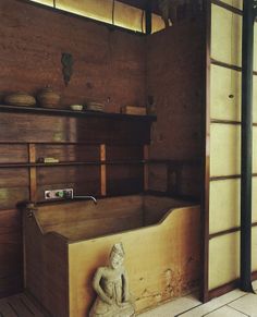 an old wooden bathtub with a statue in it